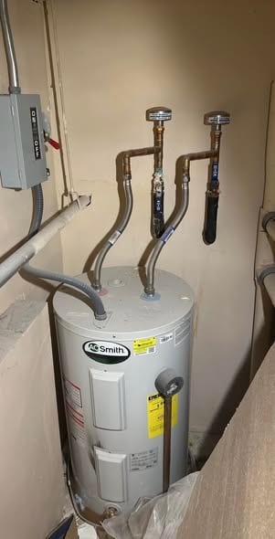 New A.O. Smith electric water heater installed in a utility closet with flex connectors and isolation valves
