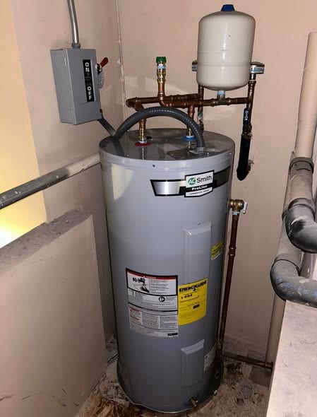 A.O. Smith water heater with new copper piping, expansion tank, and shutoff panel in a commercial utility room