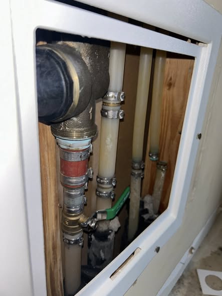 Water spraying from a burst copper water line inside the drywall of an Edmond, Oklahoma home.