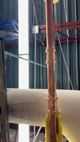New copper riser joined with press fittings inside a commercial building