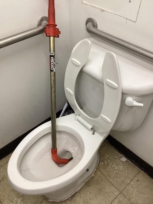 RIDGID closet auger working a commercial restroom toilet during a stoppage call