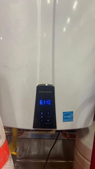 Navien tankless water heater displaying an E110 error code during a service call