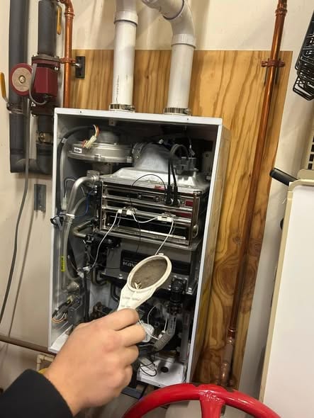 Navien tankless water heater open for service with the intake filter removed