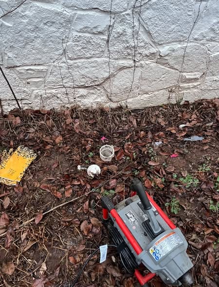 RIDGID drain machine set up at an outdoor cleanout beside the house (duplicate of root-intrusion-sewer-camera)